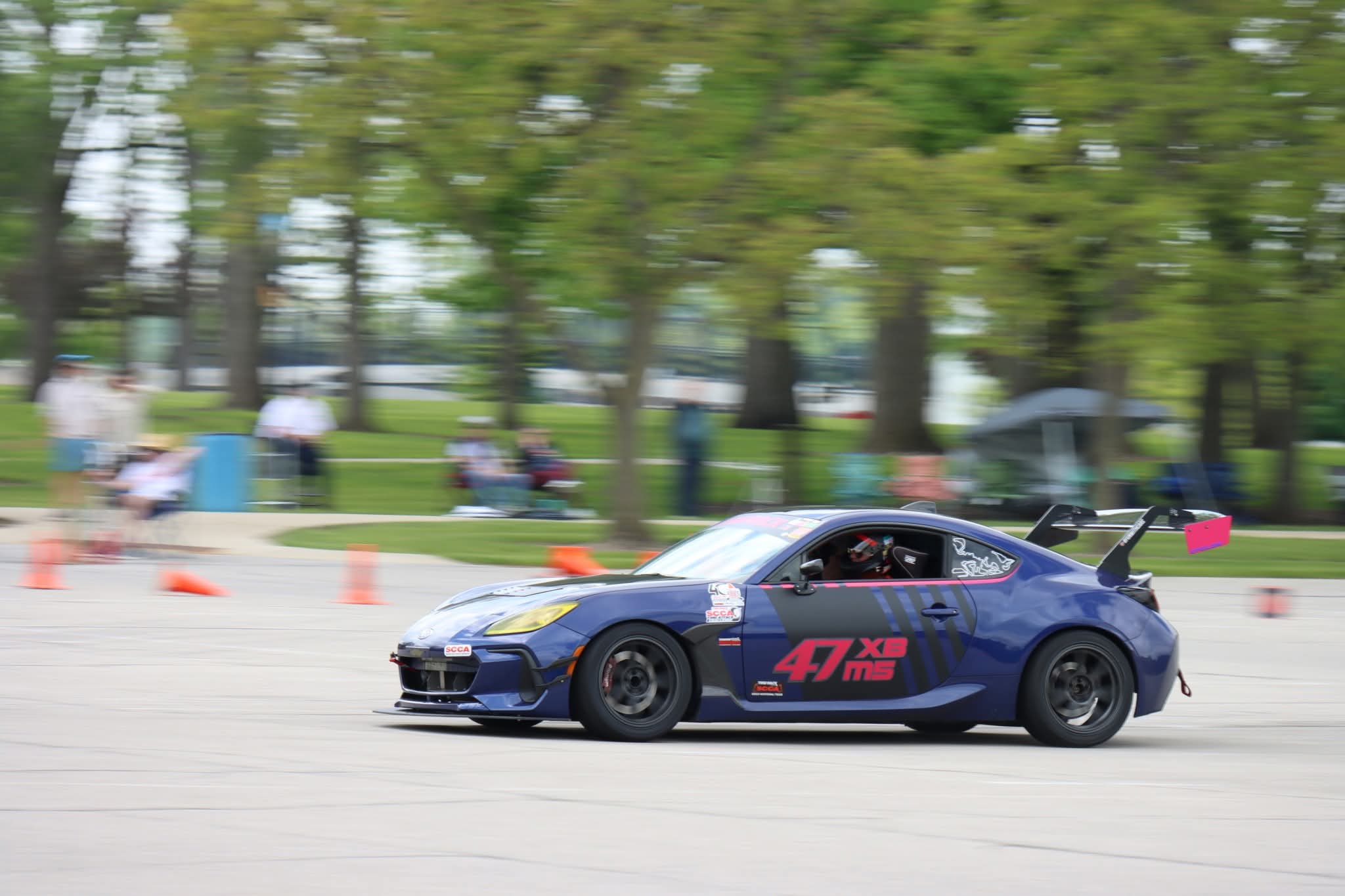 Heavily modified dark blue Subaru BRZ with number 47 XBMS large rear wing and racing livery competing at an SCCA autocross event